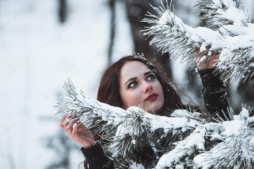 Beautiful young girl in winter forest