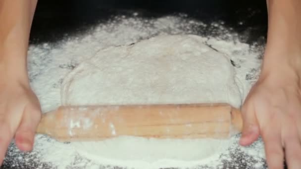 Le chef roule la pâte à pizza crue 