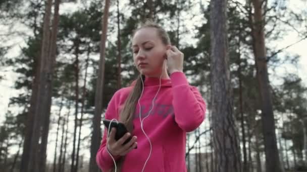 Lány a fejhallgató, és bekapcsolja a zene — Stock videók