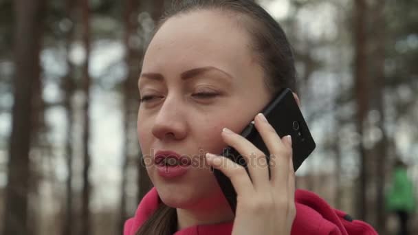 Flickan i parken talar i telefon — Stockvideo
