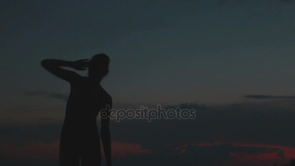 Ragazza fa yoga al tramonto sulla cima di una montagna — Video Stock