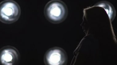 Arka plan ışığı dans bir kız silüeti. Ağır çekim