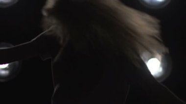 Arka plan ışığı dans bir kız silüeti. Ağır çekim