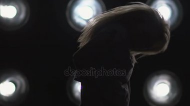 Arka plan ışığı dans bir kız silüeti. Ağır çekim