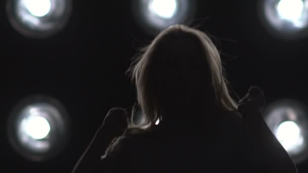 Silhouette d'une fille dansant sur les lumières de fond. Mouvement lent — Video