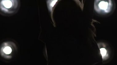 Arka plan ışığı dans bir kız silüeti. Ağır çekim