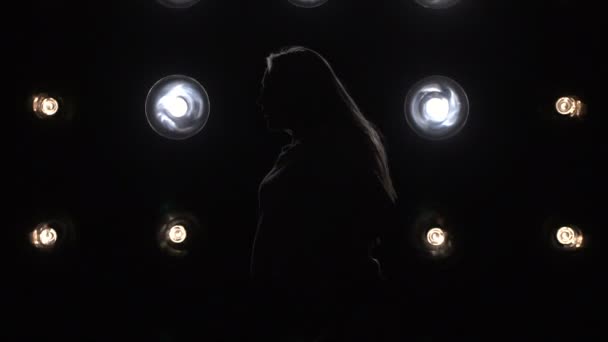 Silhouette d'une fille dansant sur les lumières de fond. Mouvement lent — Video