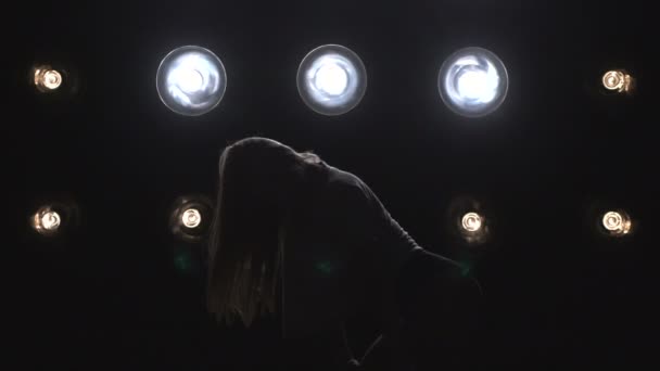 Silhouette d'une fille dansant sur les lumières de fond. Mouvement lent — Video
