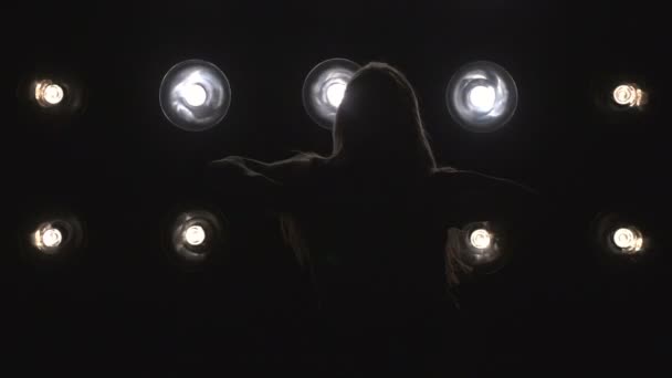 Silhouette di una ragazza che balla sulle luci di sottofondo. Rallentatore — Video Stock