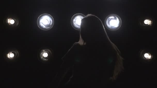 Silhouette d'une fille dansant sur les lumières de fond. Mouvement lent — Video