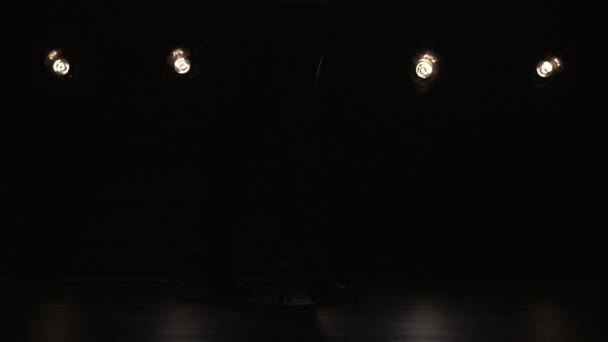 Silhuetten av en flicka dansa på bakgrunden belysningen. Slow motion — Stockvideo