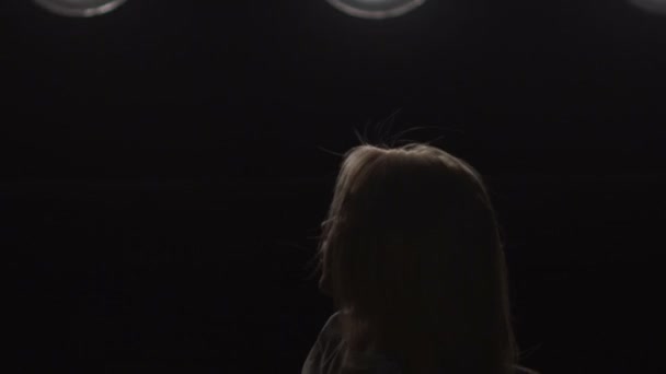 Silhouette d'une fille dansant sur les lumières de fond. Mouvement lent 