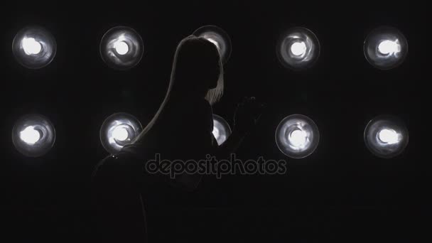 Silhouette of a girl dancing on the background lights. Slow motion — Stock Video