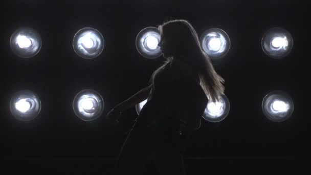 Silhouet van een meisje dansen op de achtergrond-verlichting. Slow motion — Stockvideo