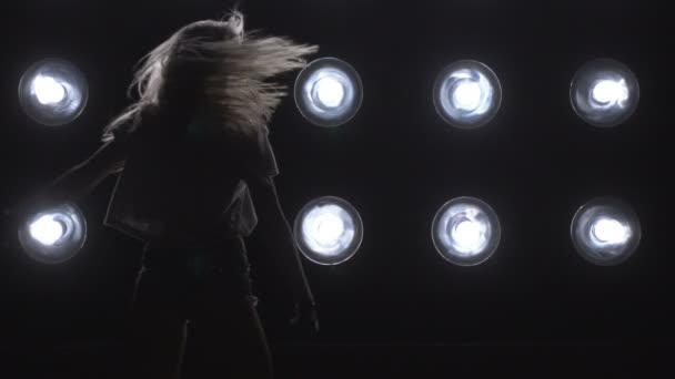 Σιλουέτα του ένα κορίτσι που χορεύει σχετικά με φόντο τα φώτα. Αργή κίνηση — Αρχείο Βίντεο