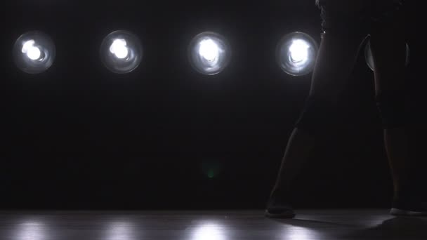 Σιλουέτα του ένα κορίτσι που χορεύει σχετικά με φόντο τα φώτα. Αργή κίνηση — Αρχείο Βίντεο