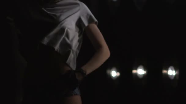 Silhouette di una ragazza che balla sulle luci di sottofondo. Rallentatore — Video Stock
