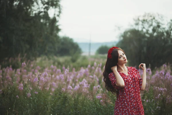 Hermosa joven en un campo en los colores de fondo — Foto de Stock
