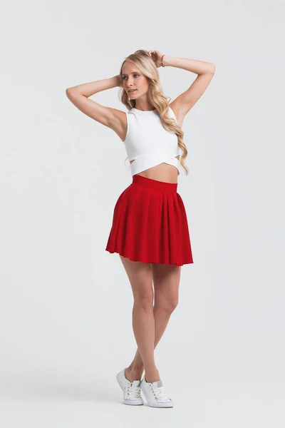 ผู้หญิงที่มีร่างกายที่สมบูรณ์แบบในกระโปรงสีแดงบนพื้นหลังสีขาว — ภาพถ่ายสต็อก