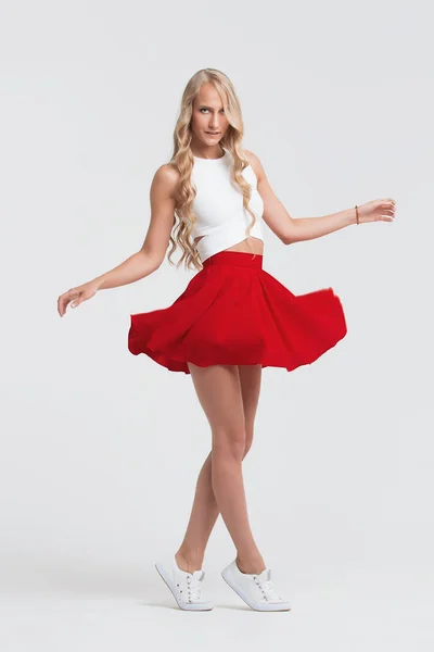 Tjej med perfekt kropp i röd kjol på en vit bakgrund — Stockfoto