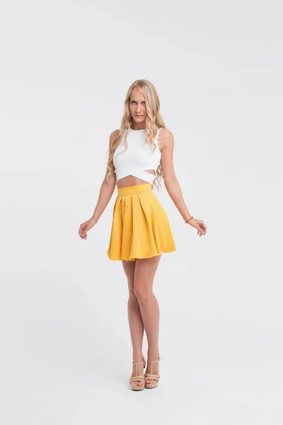Lány a tökéletes test, fehér alapon sárga szoknya — Stock Fotó