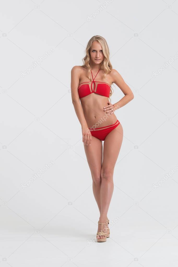 Girl with perfect body in red underwear on white background