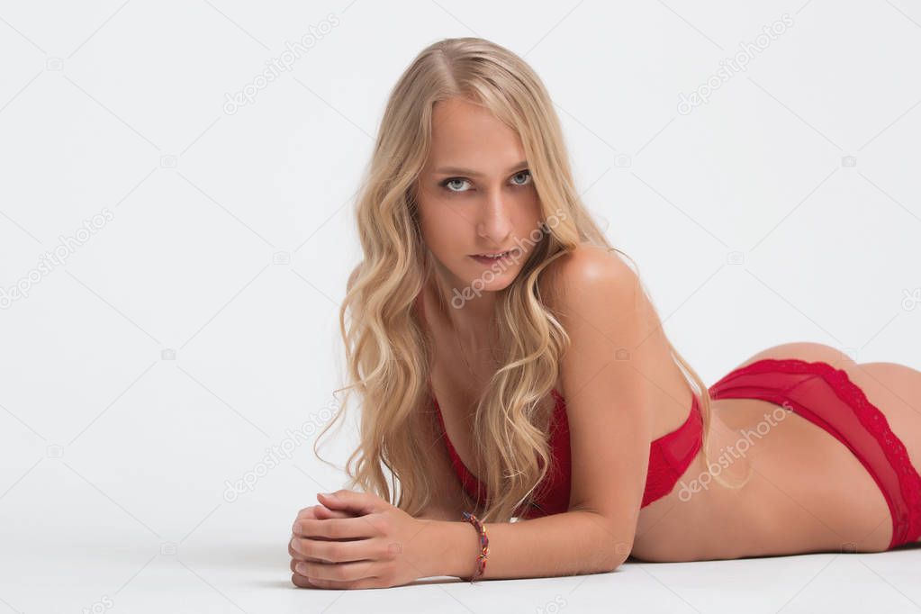 Girl with perfect body in red underwear on white background