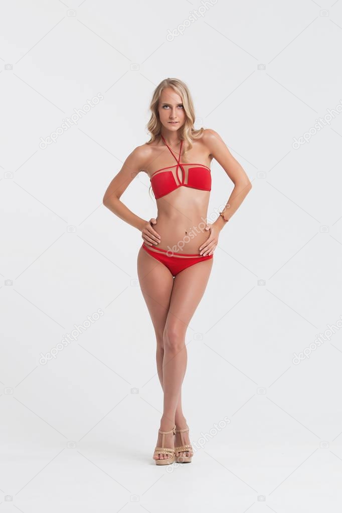 Girl with perfect body in red underwear on white background