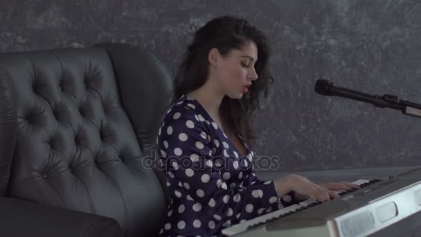 Dívka zpívat do mikrofonu a hrát na klávesnici — Stock video