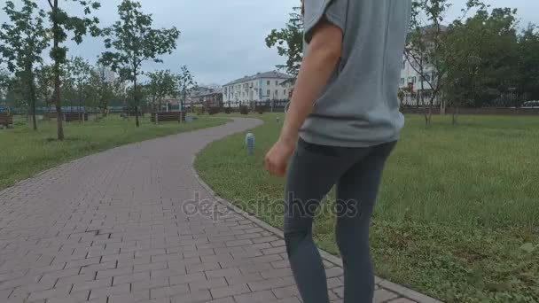 La chica va a practicar deportes en el parque. — Vídeo de stock