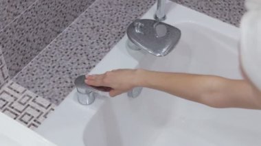 Suyun altında sabunla ellerini yıkamak.