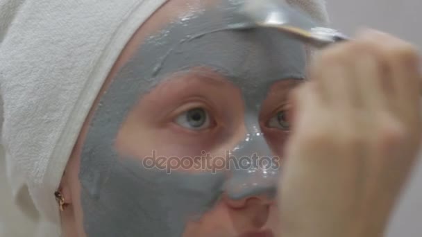 Mujer haciendo máscara cosmética en su cara — Vídeo de stock