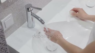 Suyun altında sabunla ellerini yıkamak.