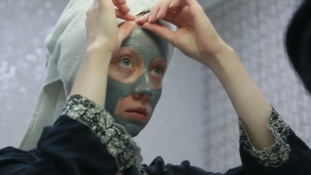 Vrouw doen cosmetische masker op haar gezicht — Stockvideo