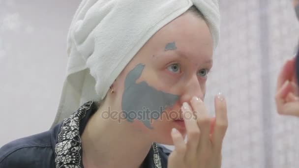 Vrouw doen cosmetische masker op haar gezicht — Stockvideo