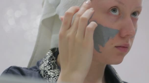 Frau macht Kosmetikmaske auf ihrem Gesicht — Stockvideo