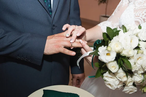 Alianças de casamento e mãos de noiva e noivo. jovem casal de casamento na cerimônia. matrimónio. homem e mulher apaixonados. duas pessoas felizes celebrando tornar-se família — Fotografia de Stock