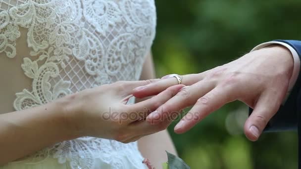 Pan młody umieszcza pierścień na rękę panny młodej. — Wideo stockowe