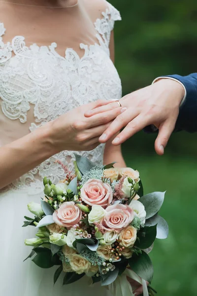 The groom places the ring on the bride's hand. Photo closeup — Stock Photo, Image