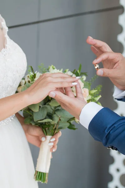 Brudgummen placerar ringen på brudens hand. Foto närbild — Stockfoto
