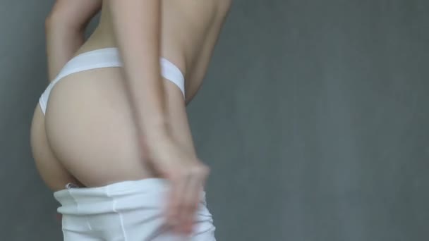 Nettes junges Mädchen versucht, sich in enge Hosen zu quetschen. — Stockvideo
