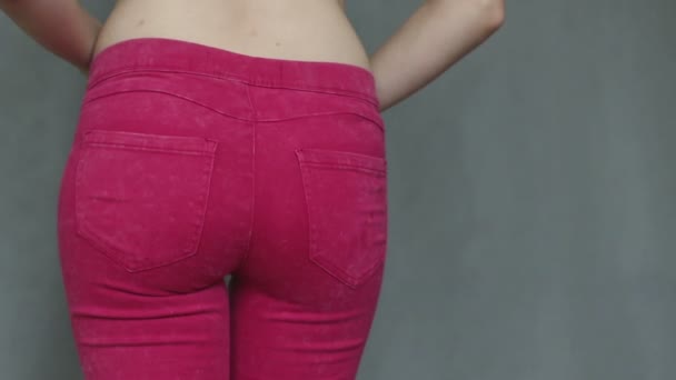 Linda chica joven tratando de apretar en jeans ajustados — Vídeos de Stock