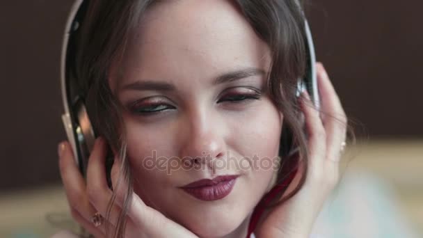 Chica feliz escuchar música en auriculares blancos y sonriendo — Vídeo de stock