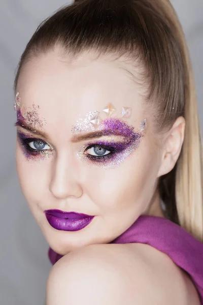 Maquillaje de belleza. Maquillaje morado y uñas brillantes de colores. Hermosa chica primer plano retrato — Foto de Stock