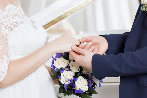 Brudgummen placerar ringen på brudens hand. Foto närbild — Stockfoto