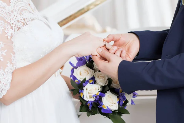 Brudgummen placerar ringen på brudens hand. Foto närbild — Stockfoto