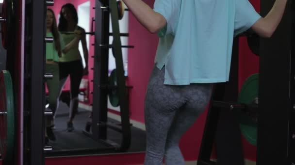 Het meisje kniebuigingen met barbell op schouders. — Stockvideo