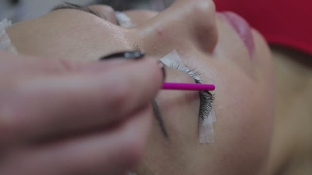 Wimpernverlängerungsverfahren. Frauenauge mit langen Wimpern. — Stockvideo