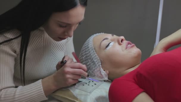 Wimpernverlängerungsverfahren. Frauenauge mit langen Wimpern. — Stockvideo