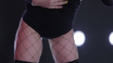 Bir spot ışığı ile duvara siyah dans kız.